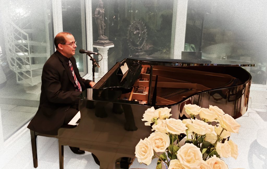 Otto Knight singing and playing a grand piano at a private event in South Florida